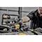 Un mécanicien utilise un outil dynamométrique DeWalt pour travailler sur un moteur. Des outils sont visibles en arrière-plan.
