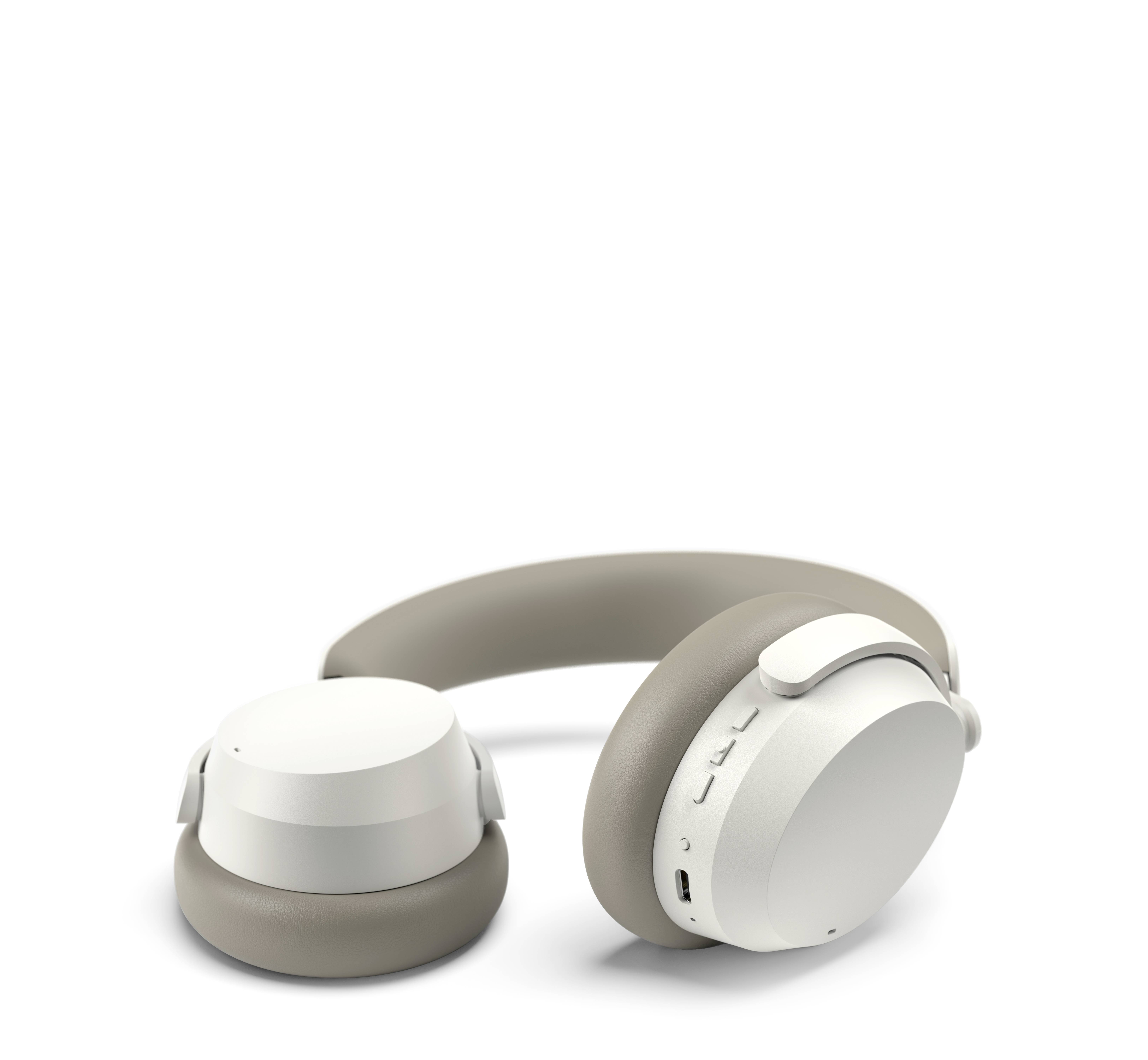 Écouteurs sans fil gris avec coques d'oreille blanches et commandes sur le côté. Conçus pour un écoute confortable et une technologie moderne.