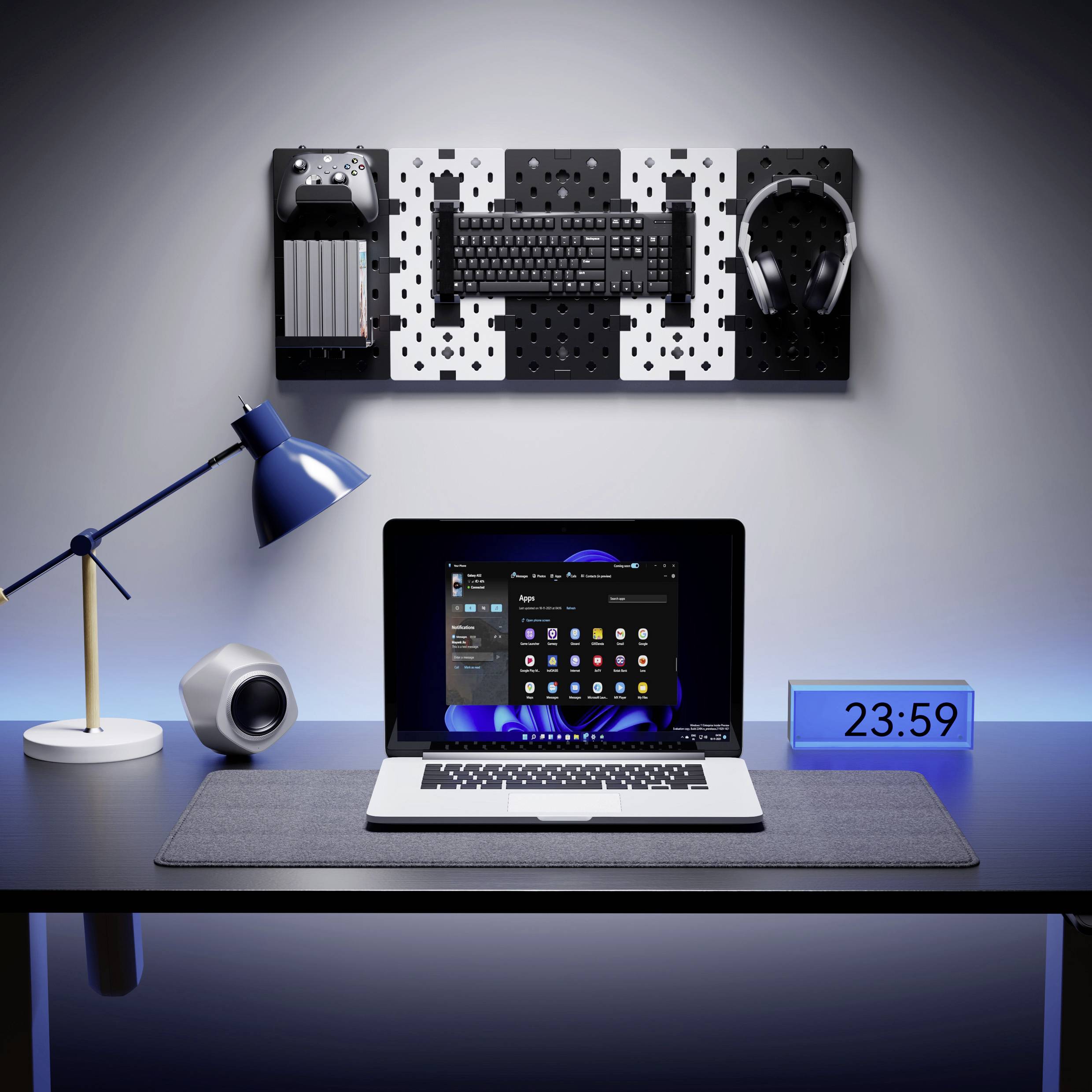 Un bureau moderne avec un ordinateur portable, un réveil, une lampe et des supports muraux pour l'électronique. Heure : 23:59.