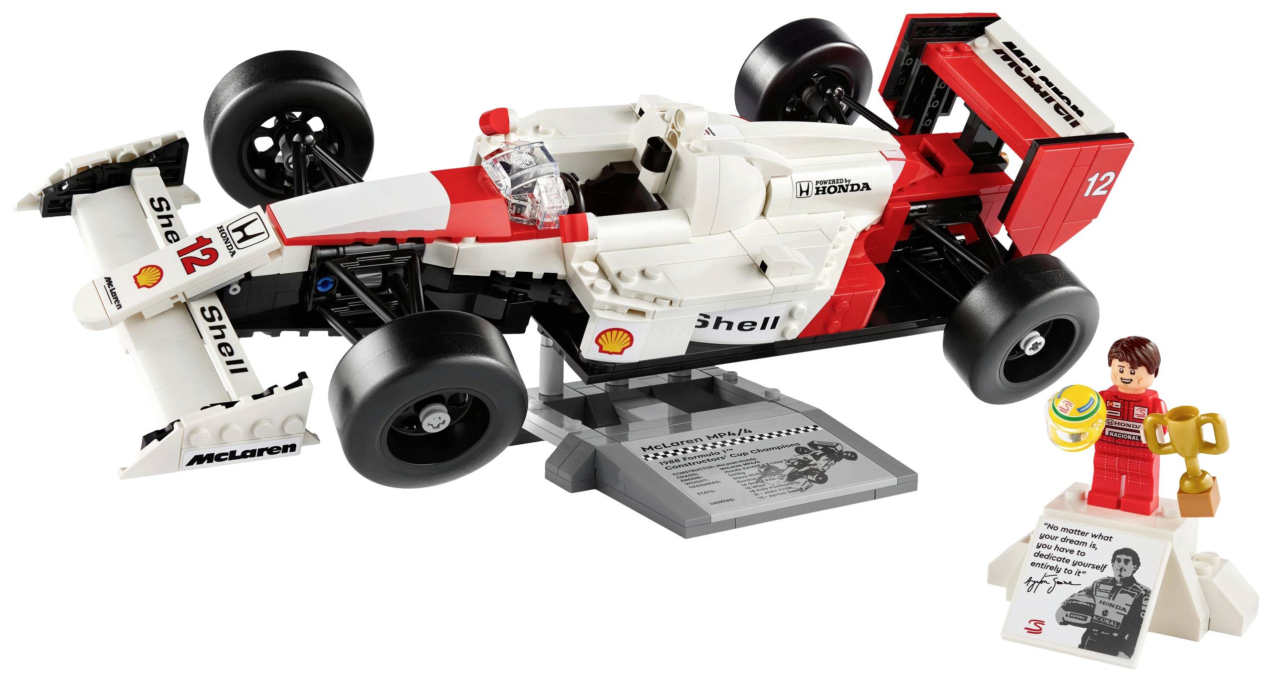 Un modèle LEGO d'une voiture de course avec des détails rouges et blancs sur un support gris. À côté se trouve une figurine LEGO portant un casque.
