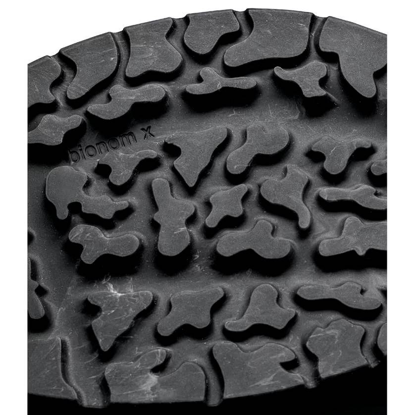Gros plan sur un profil de chaussure noir avec un motif irrégulier et organique pour une meilleure adhérence.