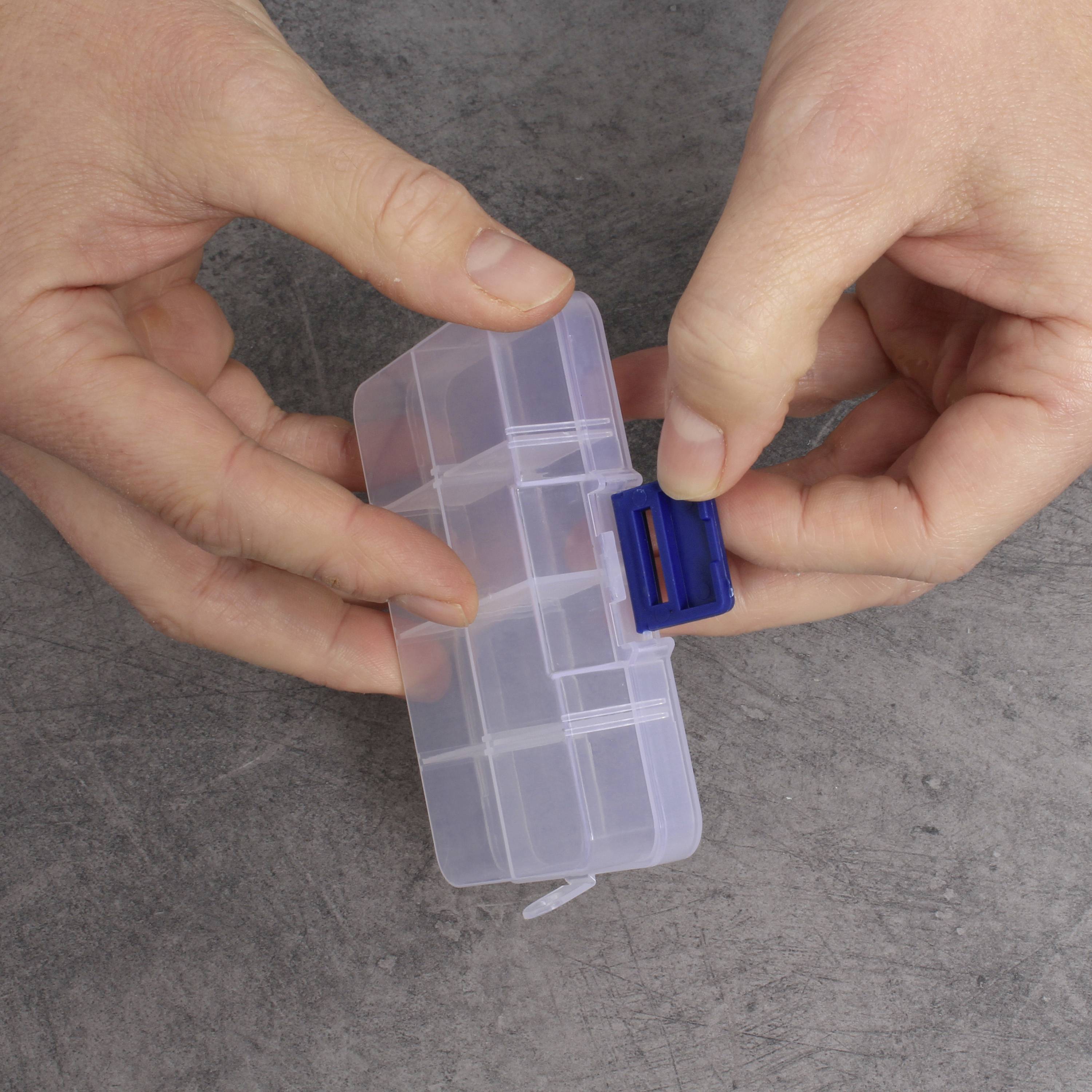 Des mains ouvrent un boîtier transparent en plastique avec un rabat de fermeture bleu.