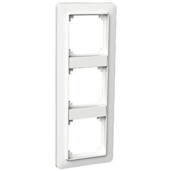Un cadre blanc, rectangulaire, triple, pour interrupteurs ou prises de courant, destiné à un montage mural, présente des ouvertures vides pour installations.