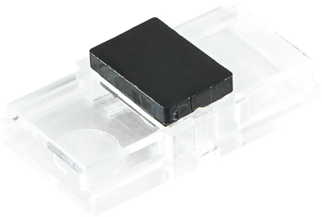 Composant électronique rectangulaire noir monté sur un bloc de plastique transparent, présenté sur un fond blanc.