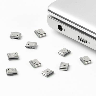 Un ordinateur portable avec plusieurs adaptateurs USB sur une surface blanche, montrant ses possibilités de connexion polyvalentes.