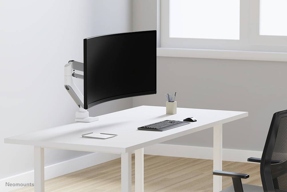 Un bureau simple et moderne avec une table blanche, sur laquelle se trouve un moniteur incurvé sur son support, un clavier, une souris et un porte-stylos.