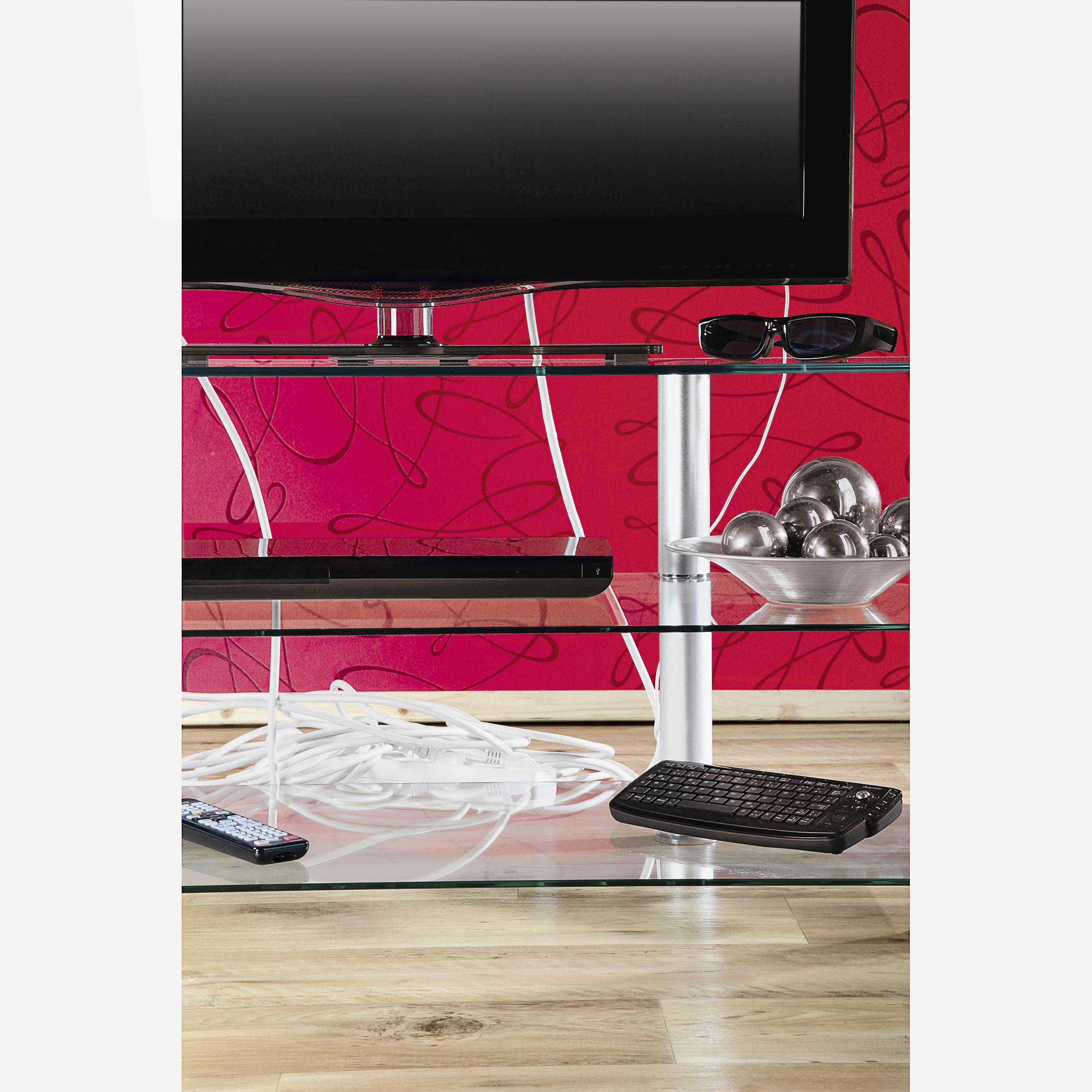 Téléviseur sur une étagère rouge avec des décorations. Des câbles, un clavier et une télécommande sont posés sur l'étagère inférieure.