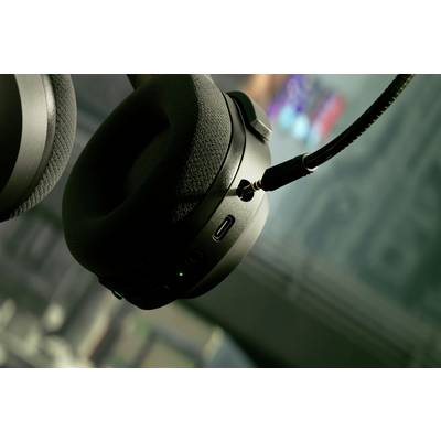 Casque noir avec microphone, légèrement incliné, sur un fond flou.