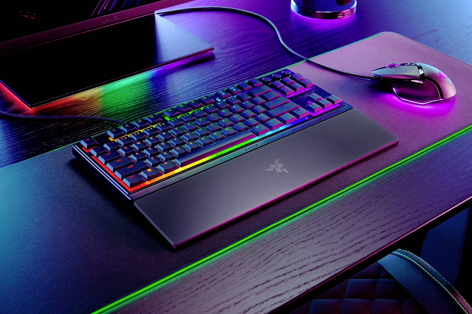 Un clavier et une souris gaming sur un bureau, tous deux équipés d'un éclairage RVB qui brille dans différentes couleurs.