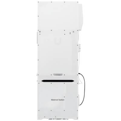 Un appareil blanc portant l'inscription « Material Station » sur sa façade ; vraisemblablement une machine industrielle ou technique.