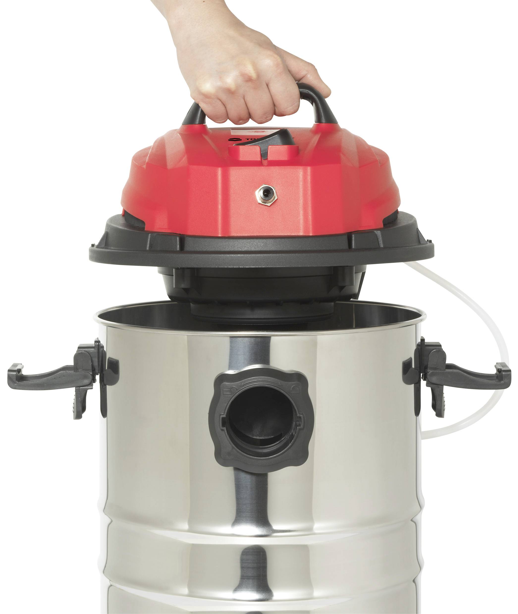 Une main soulève le couvercle rouge d'un aspirateur industriel argenté. L'aspirateur dispose de poignées latérales et d'un grand raccord de tuyau à l'avant.