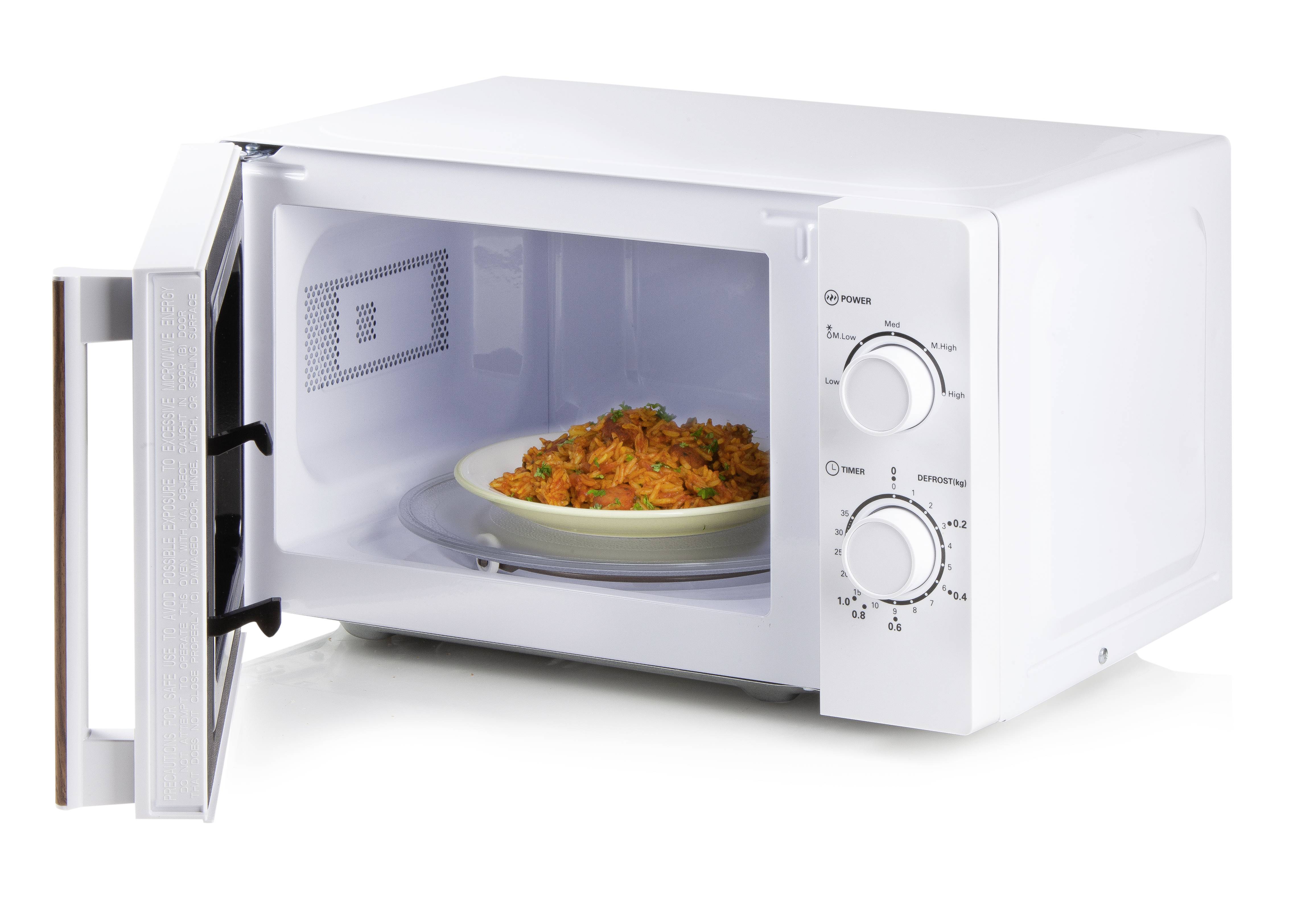 Un micro-ondes avec la porte ouverte ; à l'intérieur se trouve une assiette contenant un plat chaud. Les boutons de commande sont visibles sur le côté.