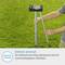 Grill compact sur support pliable dans un jardin vert. Texte : 'Facilement rangé grâce à ses pieds de support pliables.'