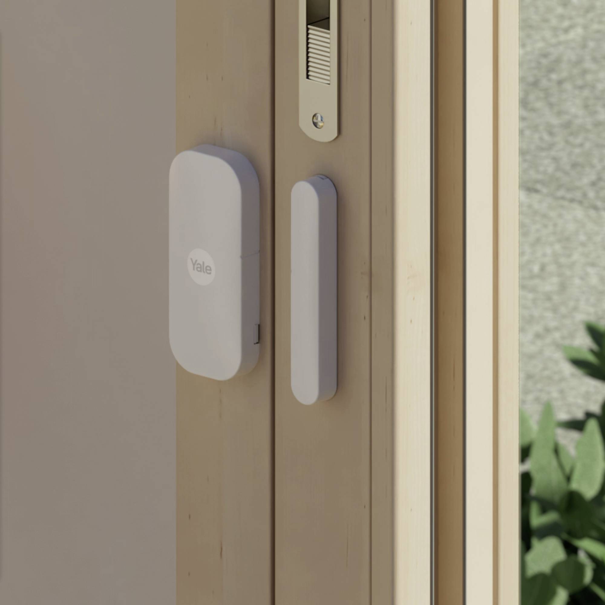 Une porte en bois équipée d'une serrure intelligente et d'un capteur de Yale, assurant la sécurité du verrouillage. Des plantes sont visibles en arrière-plan.