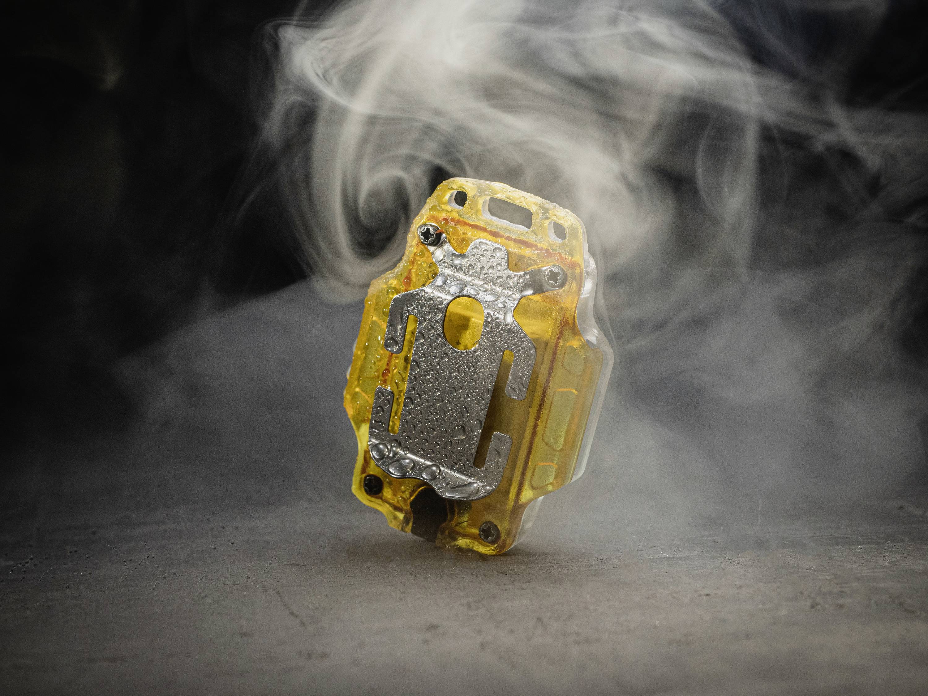 Un unique puce informatique jaune et noire, entourée de fumée. La puce se détache nettement sur un fond sombre et semble flotter.