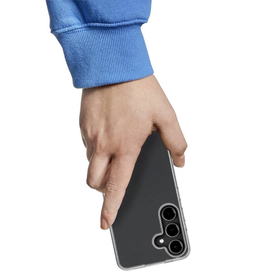 Une personne vêtue de bleu tient un smartphone moderne à trois objectifs dans sa main droite, devant un fond blanc.