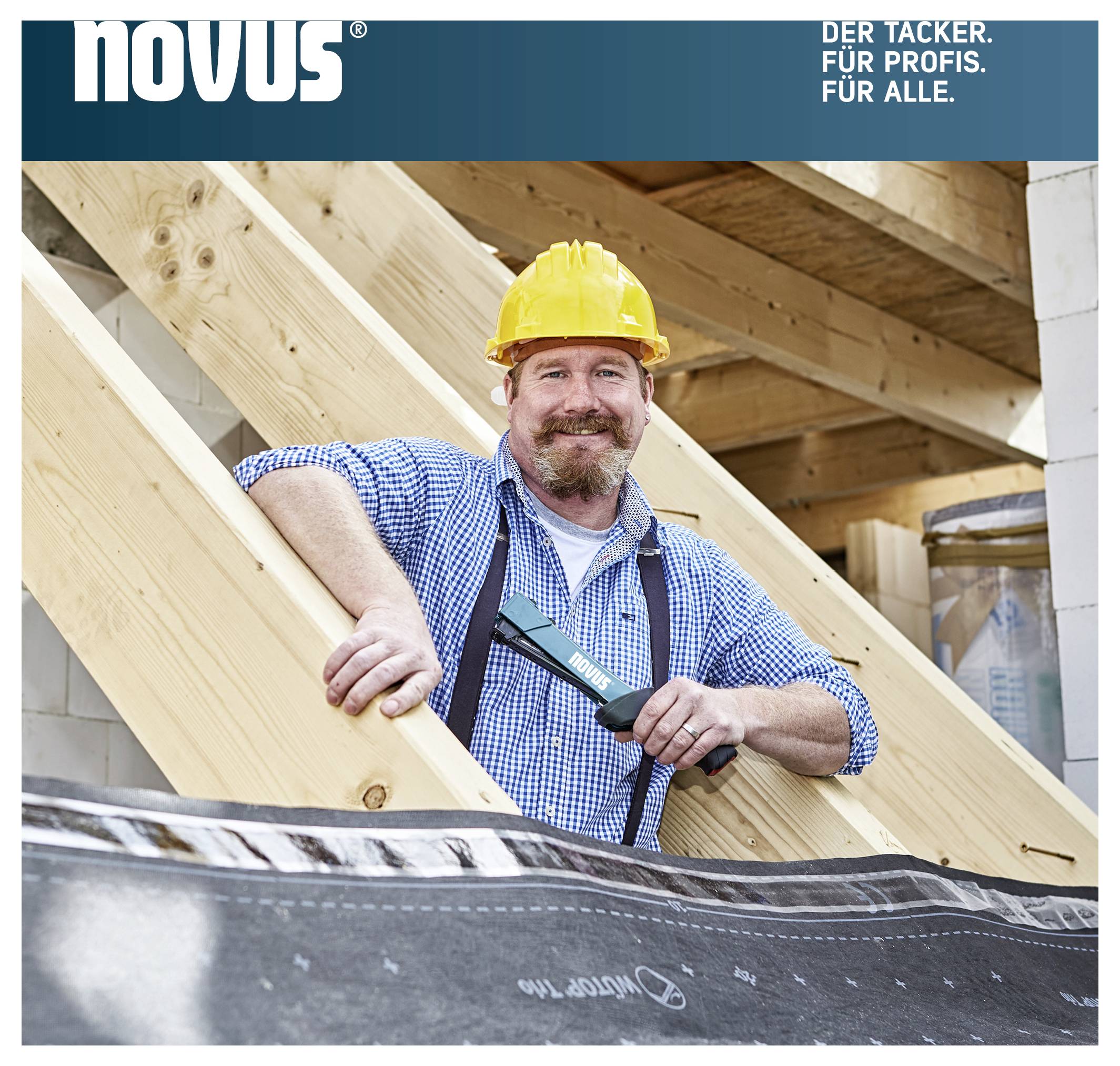 Ouvrier du bâtiment avec un casque jaune tenant une agrafeuse Novus contre une poutre en bois sur un chantier de construction ; en haut le logo et le slogan « L'AGRAFEUSE. POUR LES PROS. POUR TOUS. »
