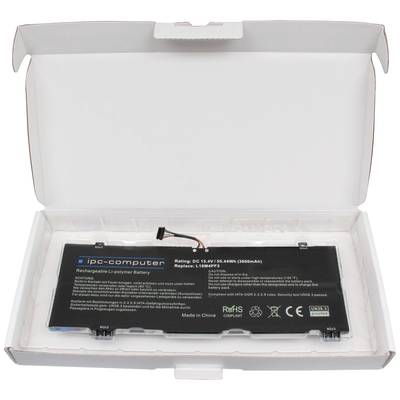 Un batterie d'ordinateur portable de 'ip-computer' est posée dans un emballage blanc ouvert. Les détails de la batterie sont imprimés sur sa surface.