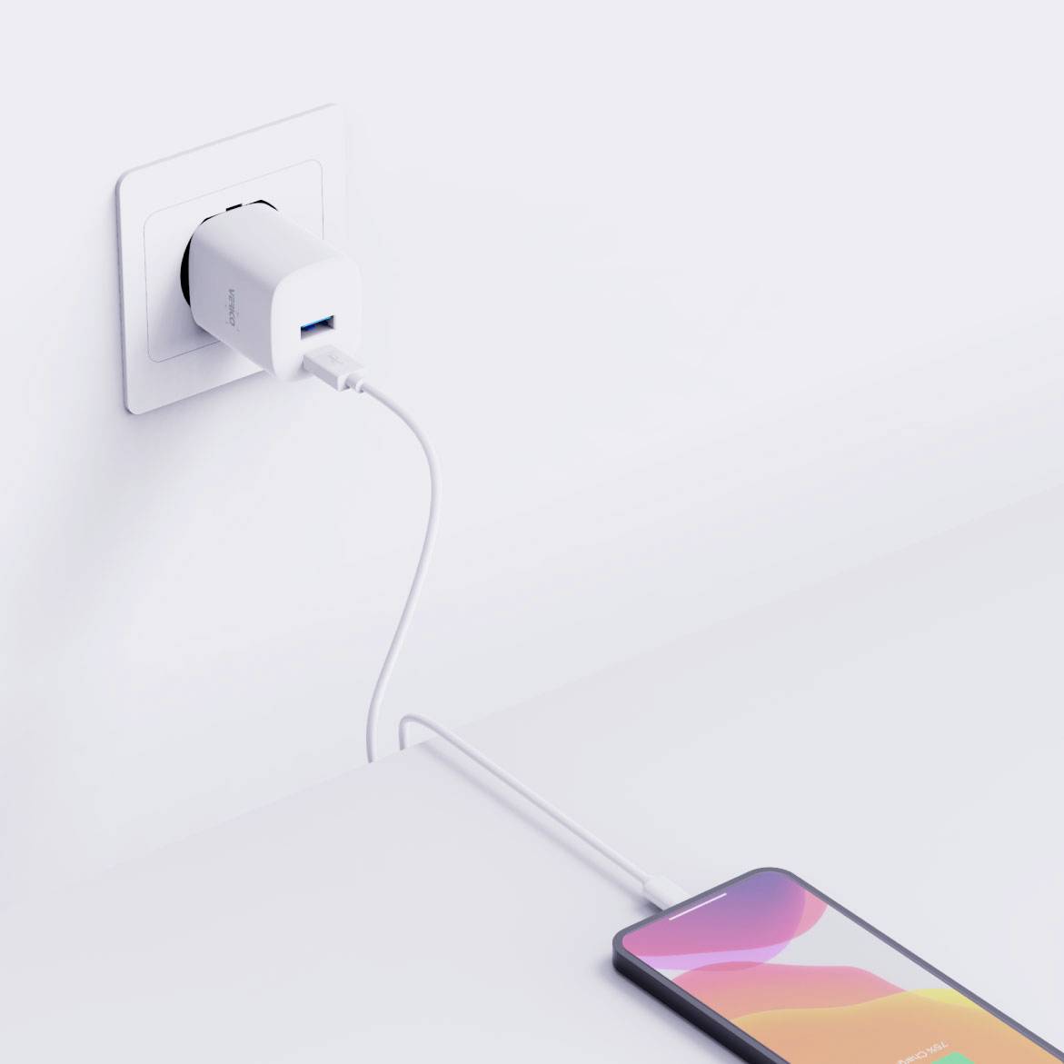 Un smartphone est chargé via un câble USB branché à un chargeur lui-même connecté à une prise murale.