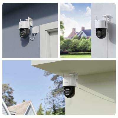Une caméra de sécurité est installée sur un mur et sous un toit, offrant une vue sur une maison et des arbres en arrière-plan.