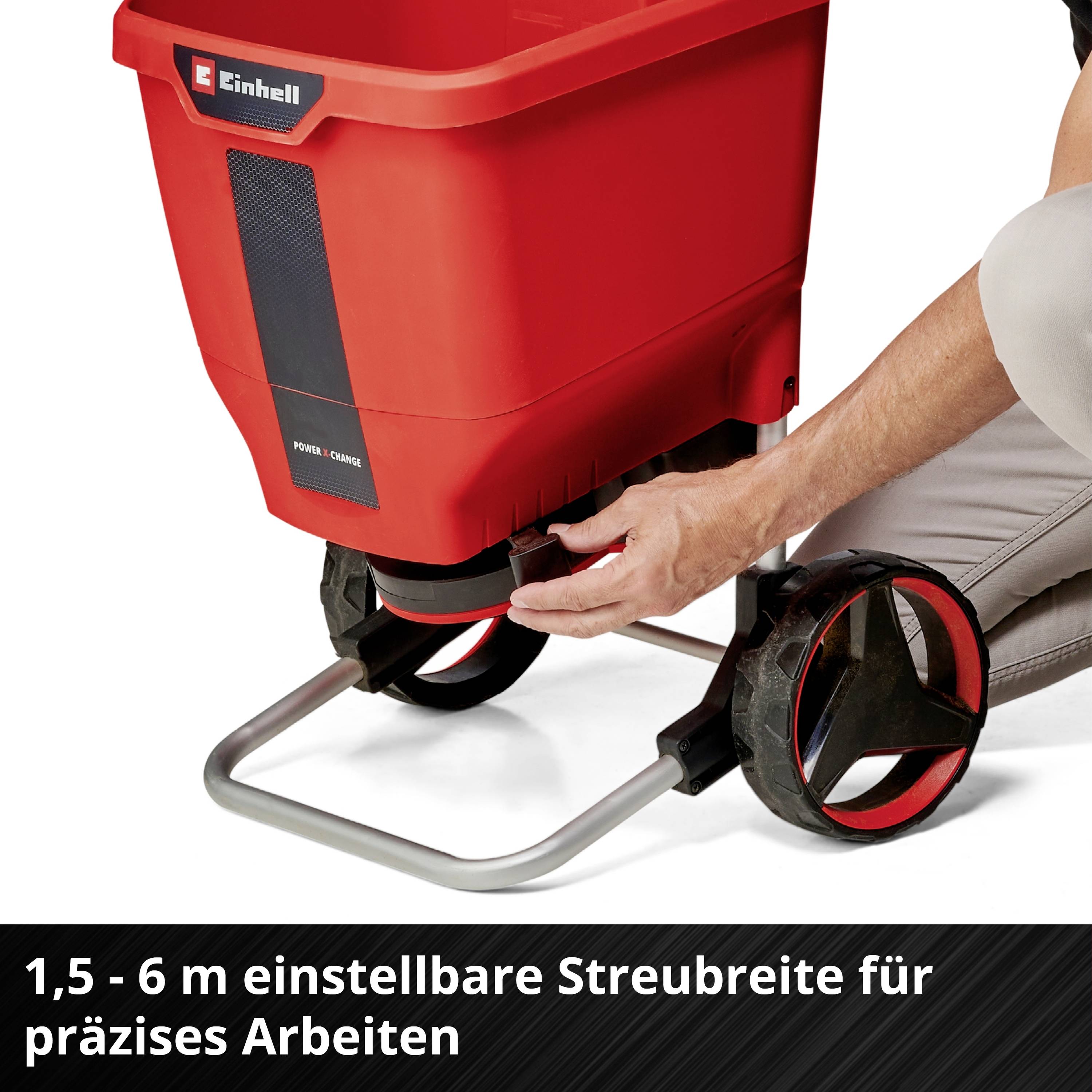 Épandeur rouge sur roues, réglable de 1,5 à 6 mètres de largeur d'épandage ; utilisé pour des tâches d'épandage précises dans le jardin.