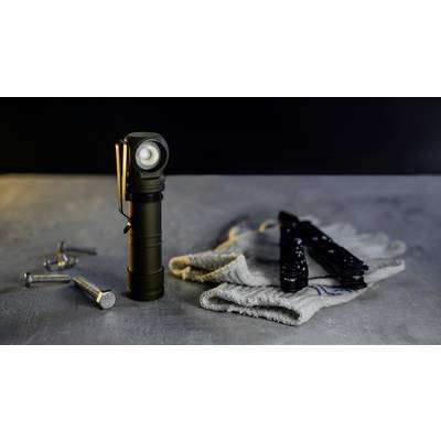 Une lampe de poche est posée sur une table à côté d'un tissu blanc et de plusieurs petites vis ; des outils sont visibles en arrière-plan.
