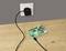 Carte informatique 'Raspberry Pi' posée sur une table en bois, branchée à un adaptateur secteur sur une prise murale.