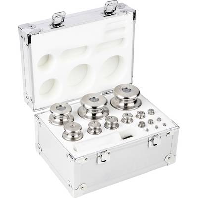 Une valise ouverte contient plusieurs poids de chrome de différentes tailles, soigneusement disposés. Utilisés pour des mesures de précision.