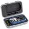 Valise ouverte contenant un appareil de mesure portable avec un écran LCD, à côté duquel se trouvent une pile AA et un étui de protection.