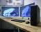 Deux moniteurs incurvés sur un bureau, à côté d'un boîtier d'ordinateur noir. Tous deux affichent l'écran de démarrage de Windows, avec un clavier et une souris devant.