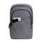 Sac à dos gris avec une petite poche avant, d'où dépassent un téléphone portable et un carnet. Design élégant avec des fermetures à glissière.