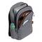 Sac à dos gris avec trois compartiments à fermeture éclair, rempli de cahiers, d'une tablette, d'une bouteille d'eau et d'un livre de poche. Idéal pour les navetteurs.