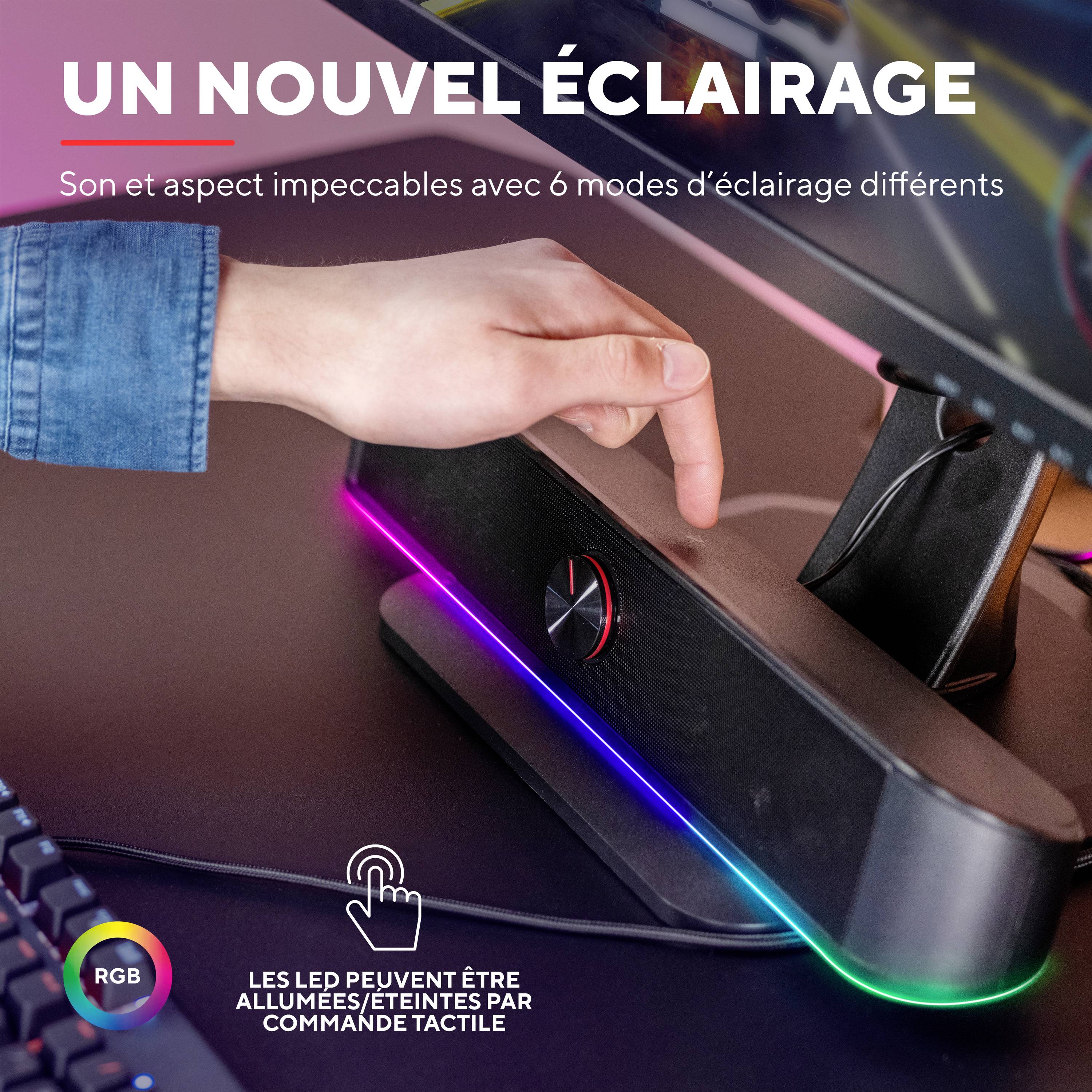 Une main touche un haut-parleur avec un éclairage LED, avec le texte 'Que la lumière soit' en dessous. Les couleurs RVB et le contrôle tactile sont mis en évidence.