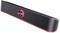 Une barre de son noire avec un éclairage LED rouge en dessous, équipée d'un grand bouton de réglage du volume central, parfaite pour des expériences audio ultramodernes.