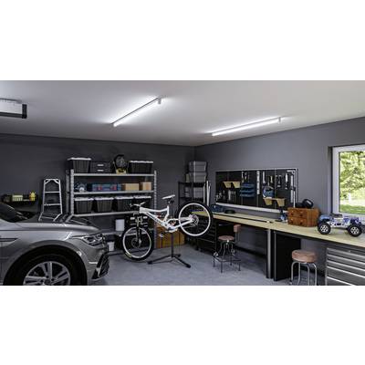 Un atelier avec une voiture, une station de réparation de vélo suspendue, des établis, des étagères avec des boîtes et des modèles réduits de voitures.
