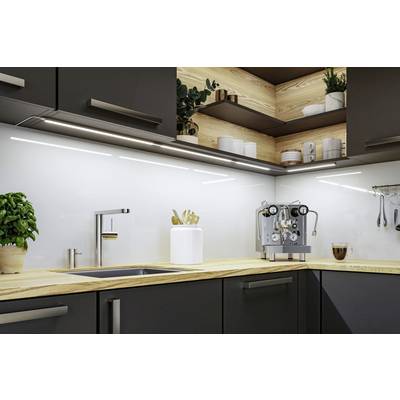 Une cuisine moderne avec des murs blancs, des étagères en bois et un robinet. Une machine à espresso et un pot de plantes sont posés sur le plan de travail.