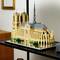 Une maquette détaillée de la cathédrale Notre-Dame réalisée en blocs de construction. Elle représente les tours, la nef principale et la façade, avec des arbres en arrière-plan.