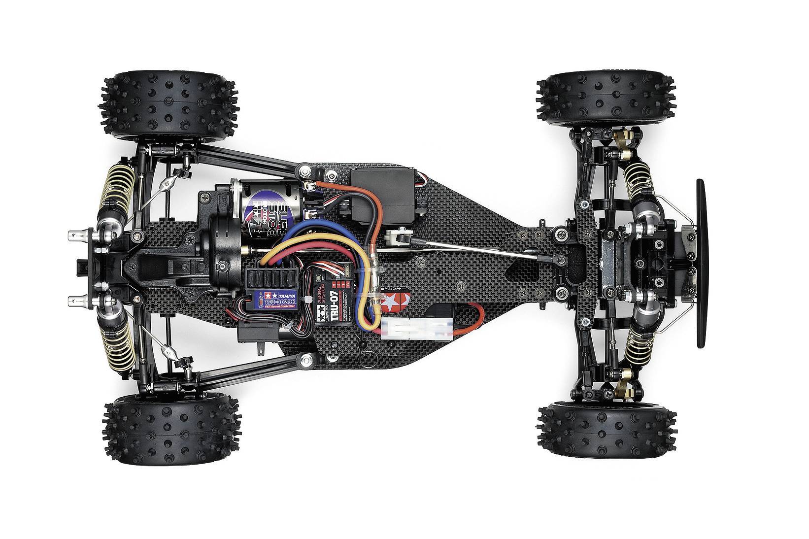 Voiture télécommandée vue de dessus, montrant le moteur, le câblage et la suspension. Des pneus tout-terrain et un châssis en fibre de carbone sont visibles.