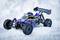 Une voiture télécommandée bleu et jaune avec des roues noires est garée dans la neige. Elle possède un grand aileron arrière pour assurer sa stabilité.