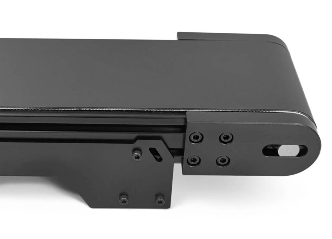 Support en métal noir avec des surfaces planes et plusieurs vis, probablement un composant d'un dispositif technique ou industriel.