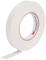 Rouleau de ruban isolant blanc sur fond blanc, partiellement déroulé.