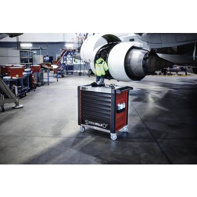 Chariot d'atelier Stahlwille sur roulettes devant un moteur d'avion dans un hangar de maintenance. Des outils sont visibles en arrière-plan.