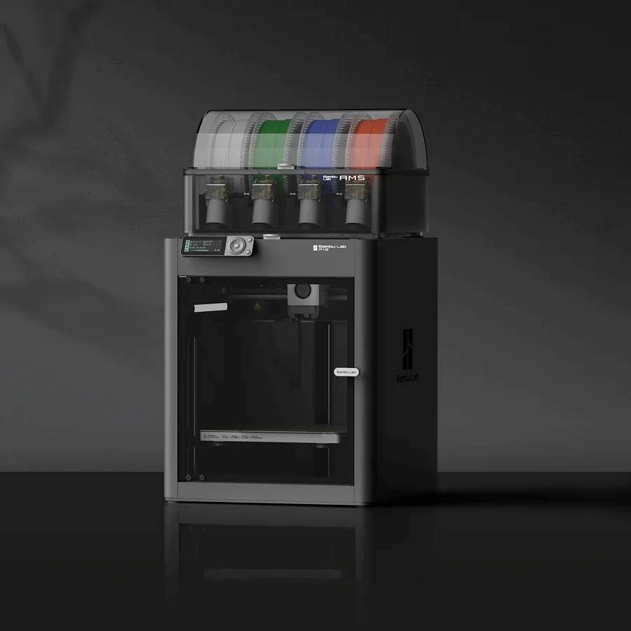 Un imprimante 3D moderne avec plusieurs bobines de filament en haut. L'écran affiche des informations de statut. Fond noir.