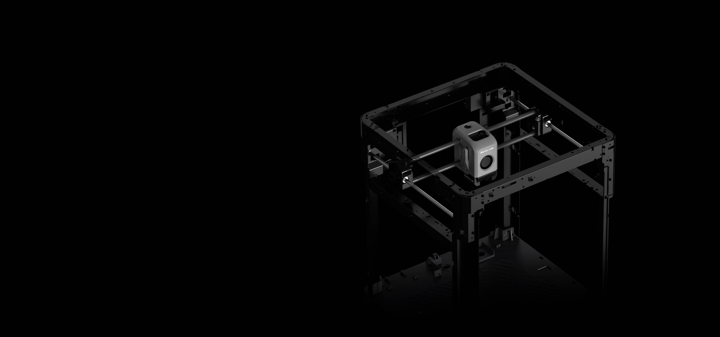 Une imprimante 3D dans une pièce noire. La tête d'impression est au centre, entourée d'un cadre ouvert, prête à commencer l'impression.