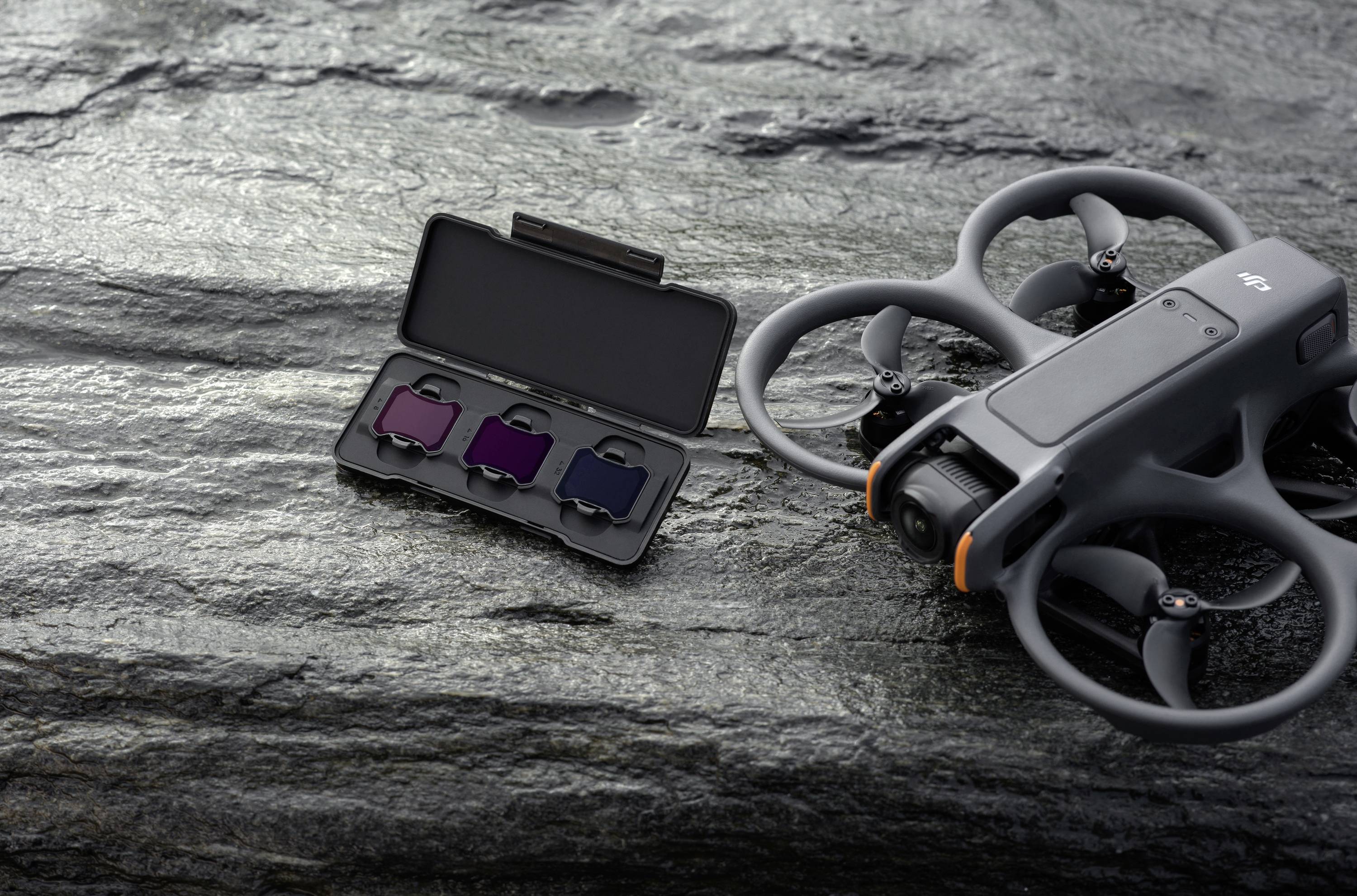 Kit de drone sur fond rocheux : Un drone gris avec caméra et un étui contenant trois filtres photo. Parfait pour la photographie en extérieur.