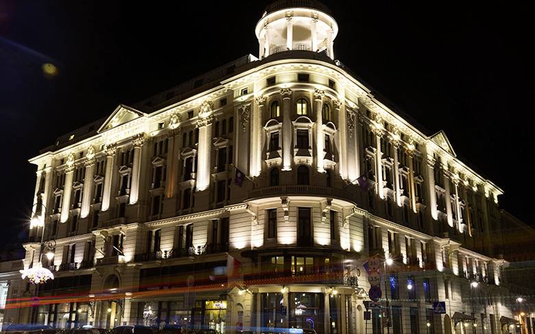 Un magnifique bâtiment historique illuminé la nuit. Il dégage une élégance et se détache sur le fond du ciel sombre.