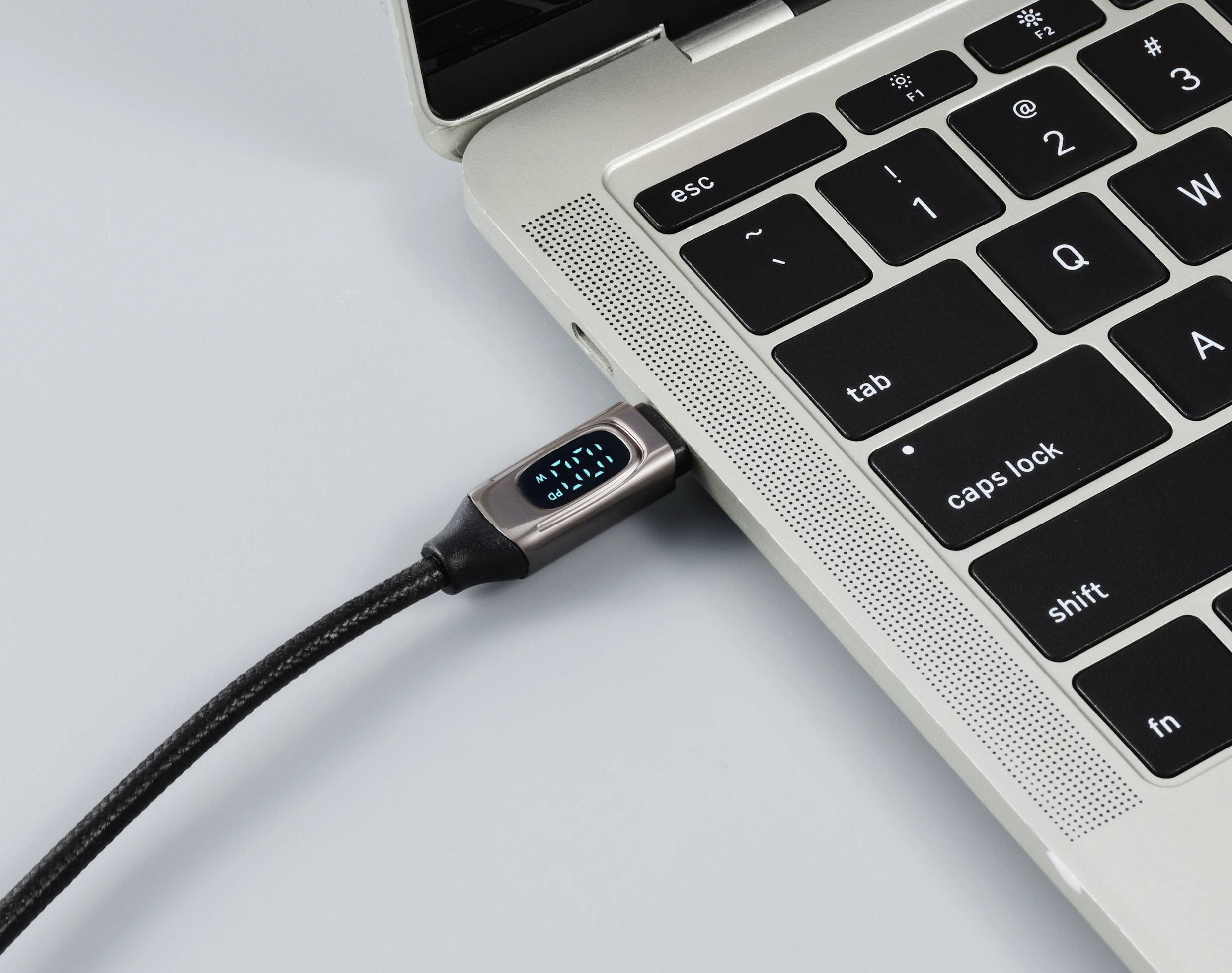 Un ordinateur portable avec un câble de chargement branché dans le port USB. L'écran n'est pas visible. Il symbolise la charge d'un appareil.