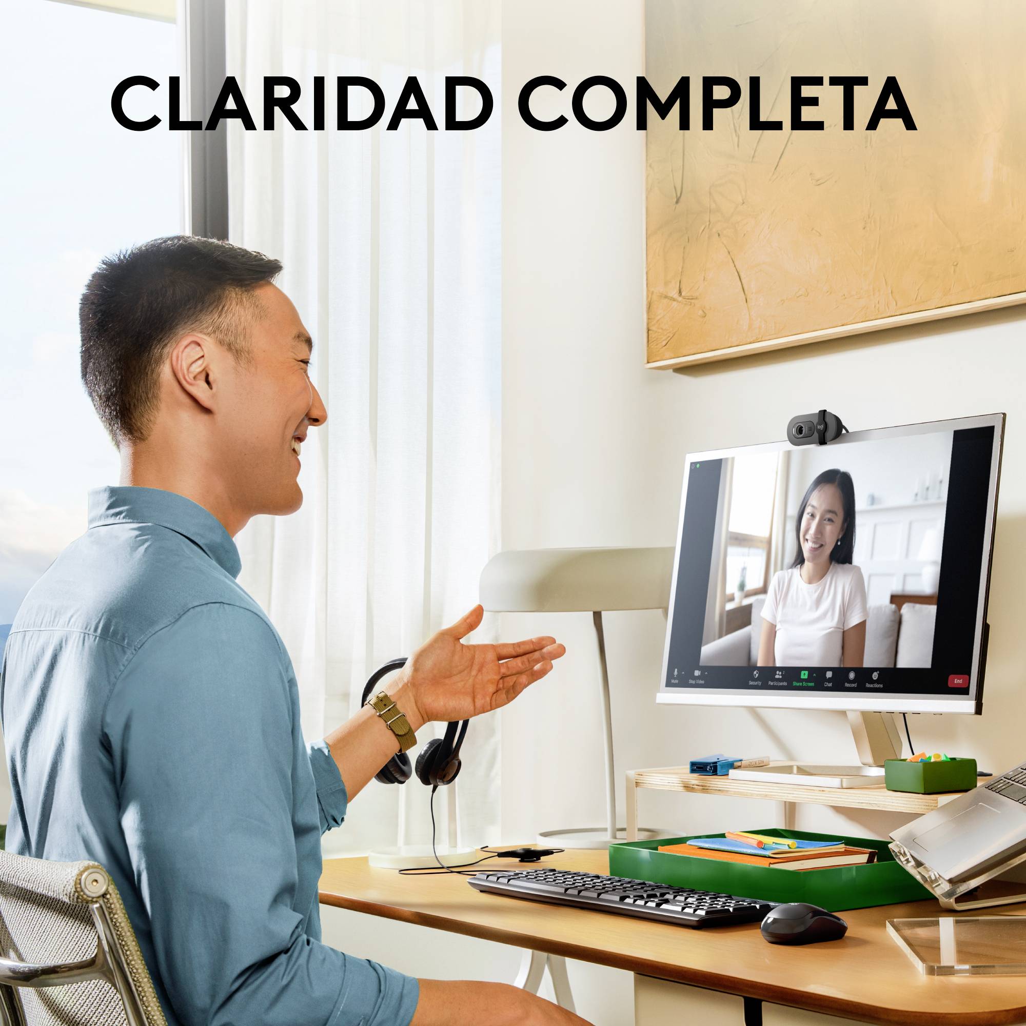 Un homme est assis à un bureau et mène un appel vidéo. Une femme est visible à l'écran. En haut est écrit 'CLARIDAD COMPLETA'.