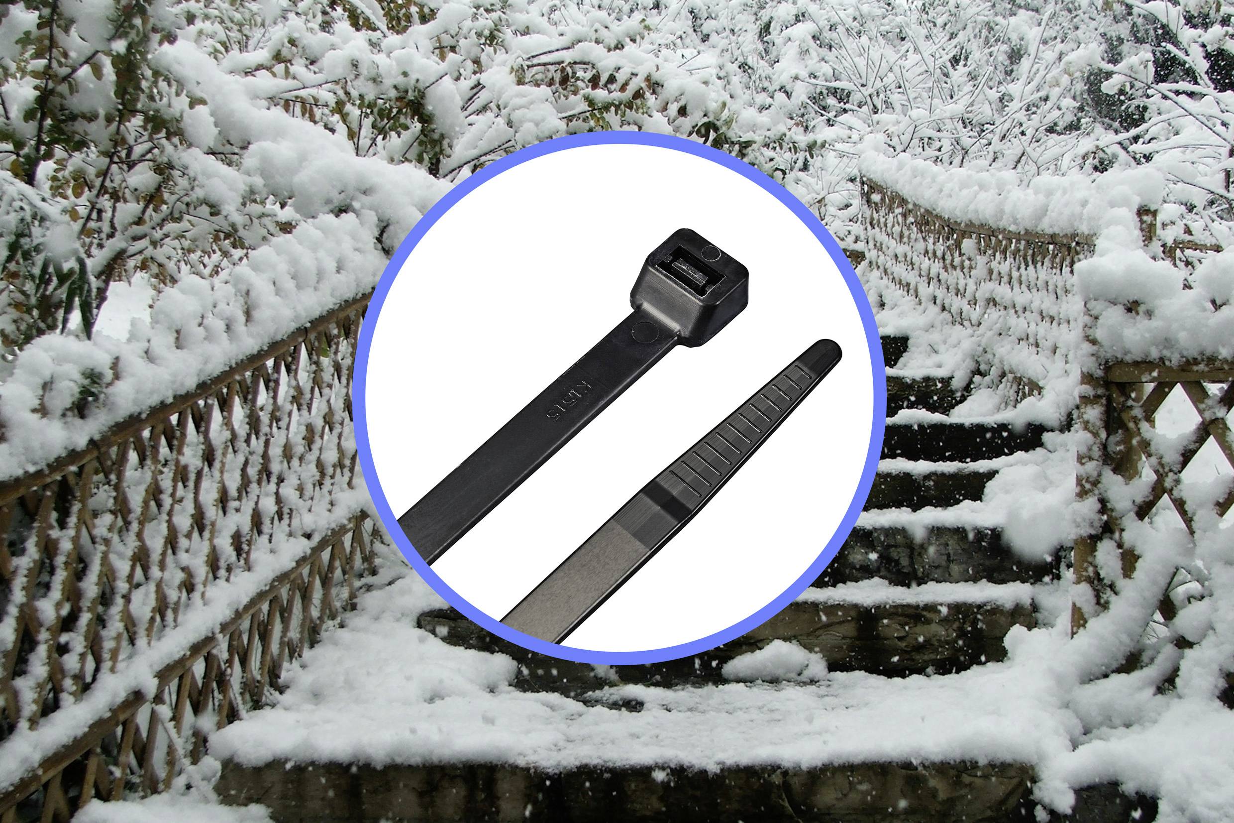 'Escalier enneigé dans un parc d'hiver. Gros plan de serre-câbles noirs au premier plan.'