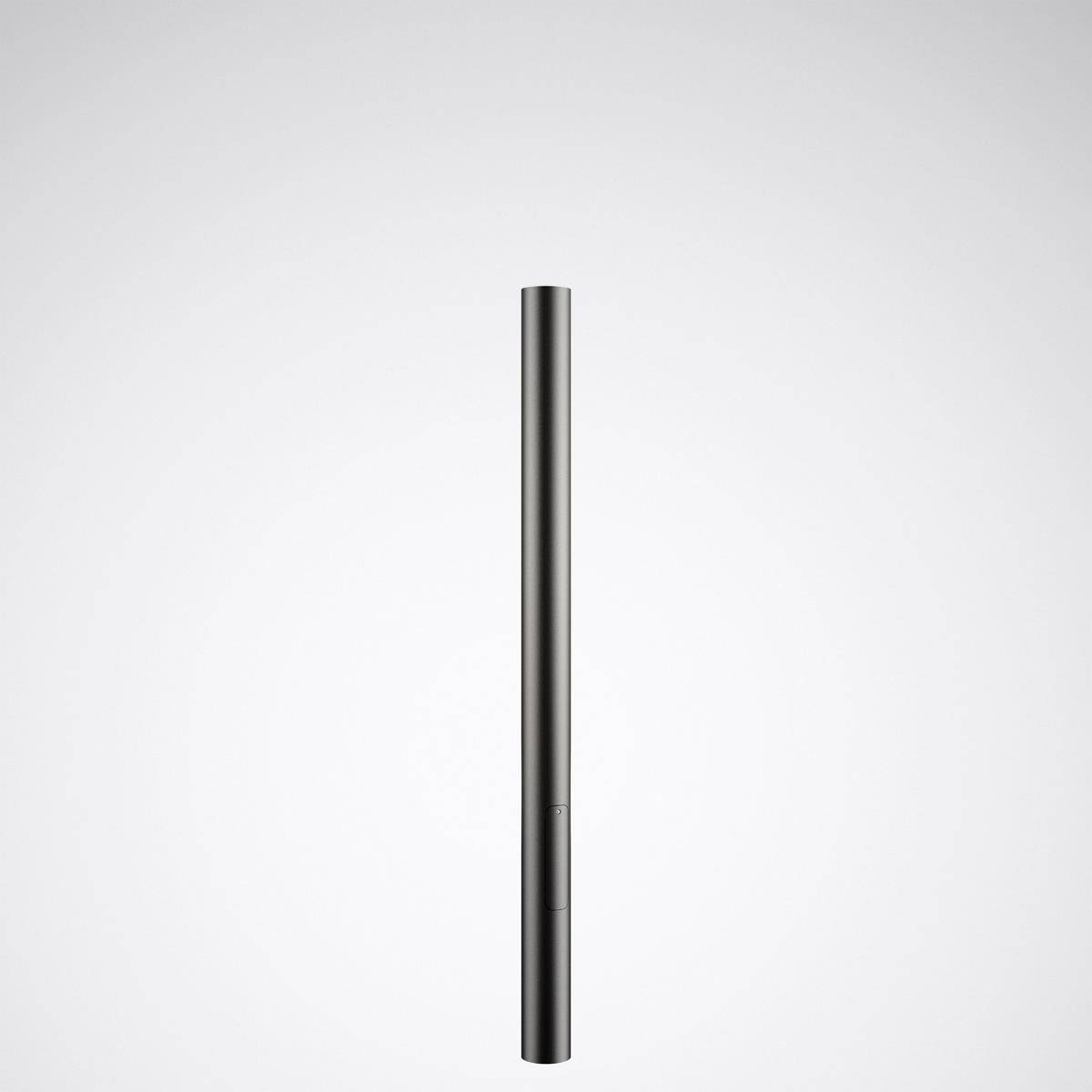 Un microphone à condensateur noir et élancé, positionné verticalement devant un fond gris clair.